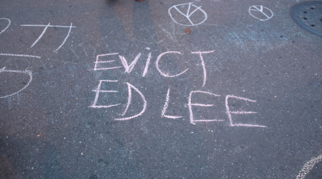 Protestors chalk "Evict Ed Lee" on the Valencia and 21st intersection. Photo by: Sana Saleem